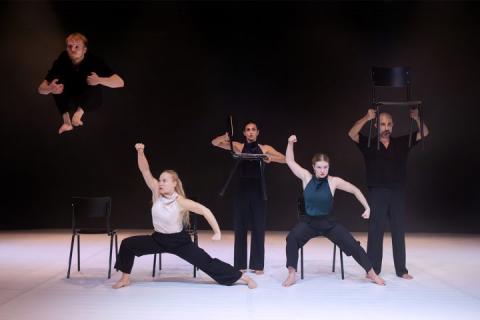 Groupe de danseurs sur sc&egrave;ne avec des chaises 